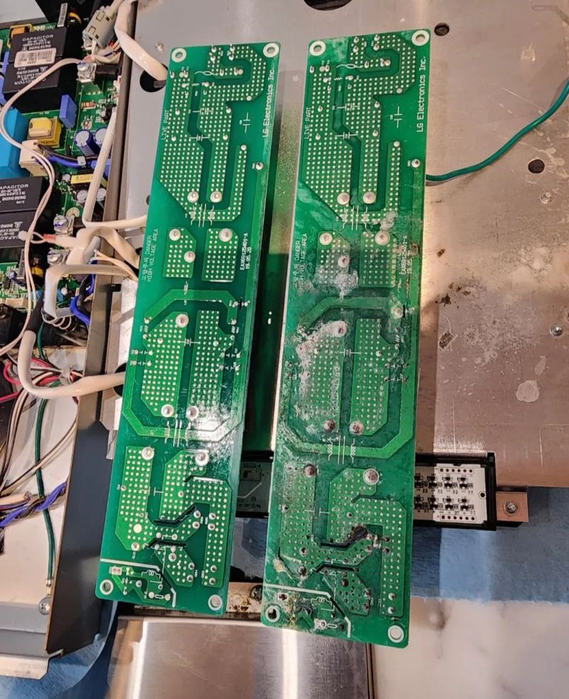 Two green electronic circuit boards with visible components and wiring on a metal surface.