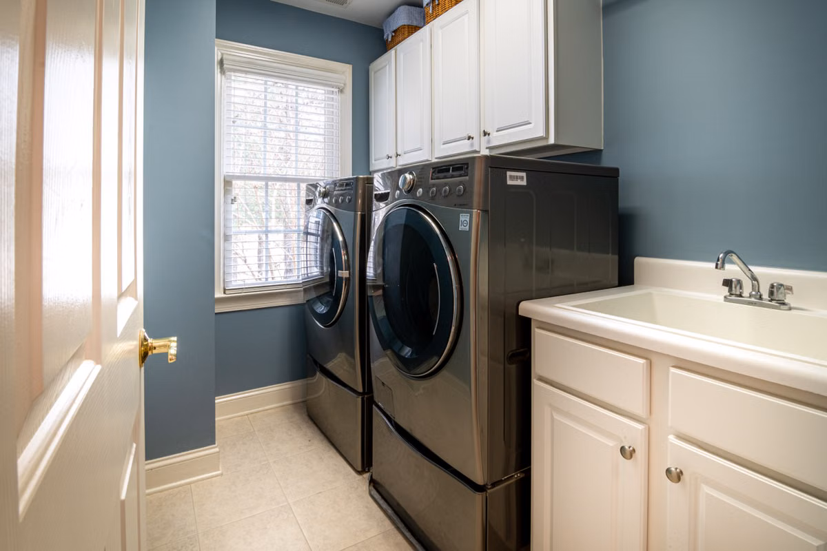 A clean, organized laundry room featuring modern appliances and ample storage.